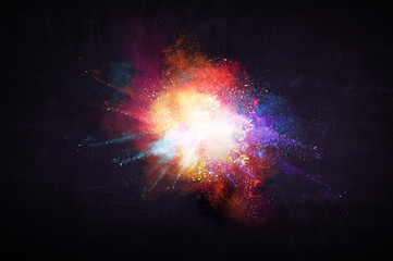 Freeze motion of color powder exploding on black background.
