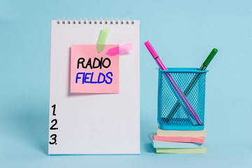 Text sign showing Radio Fields. Business photo showcasing electromagnetic field intensity consisting of an electric Spiral notebook sticky note banners stacked pads pens holder pastel back