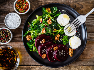  Beetroot salad with goat cheese on wooden background