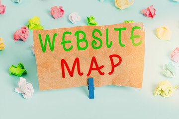 Text sign showing Website Map. Business photo text designed to help both users and search engines navigate the site Colored crumpled papers empty reminder blue floor background clothespin