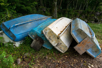 Old wooden fishing boats lying overturned on a grass