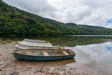 Two traditional wooden fishing boats on a river bank