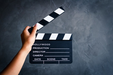 Women hands holding clapper board for making video cinema in studio.