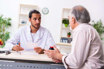 Old man visiting young male doctor cardiologist