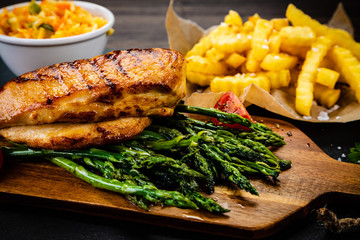 Grilled chicken fillet and vegetables on stone board
