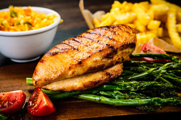 Grilled chicken fillet and vegetables on stone board