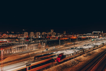View over Aarhus at night with trains in foreground and buildings in background