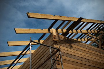 the process of building a house, a roof against the sky