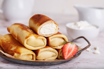 Thin crepe pancake rolls stuffed with cottage cheese. Traditional Russian cuisine. Crepe week. Maslenitsa.