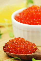 A small ceramic bowl with red caviar	