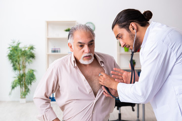 Old man visiting young male doctor cardiologist