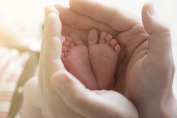 Obraz na płótnie Canvas A close-up tiny baby feet. Childcare, safety and education concept.