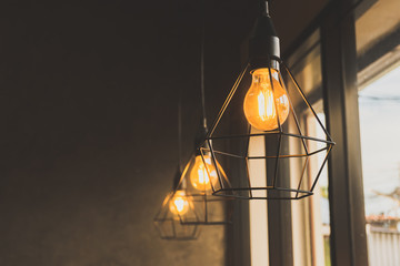 light bulb in black steel cage hang on ceiling in coffee shop, Fashion and lamp in modern style.