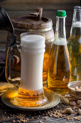 Light beer in a glass on a table in composition with accessories on an old background