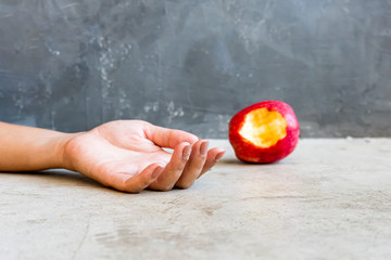 woman hand put in ground near red apple,Contaminated food concept,Food poisoning concept.