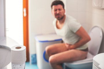 Man in the bathroom suffering from stomach pain