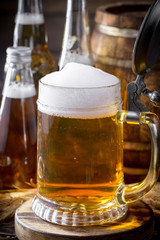 Light frothing beer in a glass, on an old background.