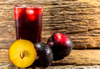 Glass of fresh plum juice and fruits (Prunus domestica)