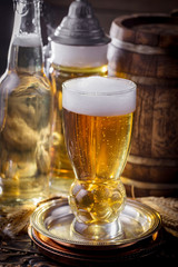 Light beer in a glass on a table in composition with accessories on an old background