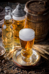 Light beer in a glass on a table in composition with accessories on an old background