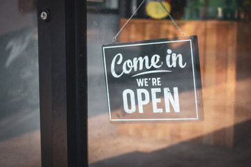 A business sign that says 'Come in We're Open'. - Powered by Adobe