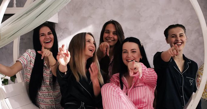 Waist up of happy women celebrating her friend bachelorette party while having fun together. Pajama party before the wedding