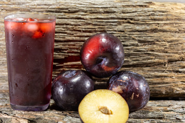 Glass of fresh plum juice and fruits (Prunus domestica)