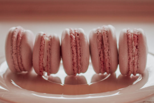 Strawberry french macarons closeup. Fresh and colourful on pink background