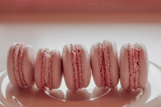 Strawberry french macarons closeup. Fresh and colourful on pink background