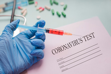 test for coronovirus in an epidemic with a syringe blood test in the labarotorium and a sheet of...