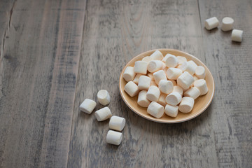 A lot of sweet marshmallows in a brown plate
