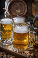 Light frothing beer in a glass, on an old background.