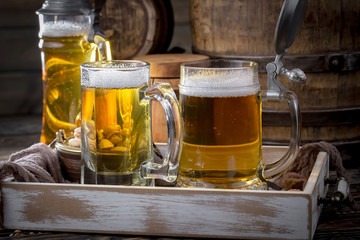 Light frothing beer in a glass, on an old background.