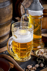 Light frothing beer in a glass, on an old background.