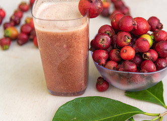 Glass of juice and fruits of red aracá (Psidium cattleyanum Sabine) in natura