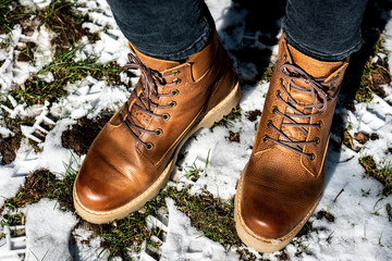 Woman wearing leather boots in winter frozen nature.