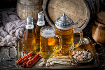 Light frothing beer in a glass, on an old background.