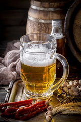 Light frothing beer in a glass, on an old background.