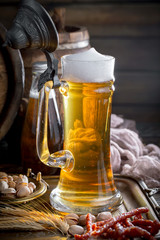 Light beer in a glass on a table in composition with accessories on an old background