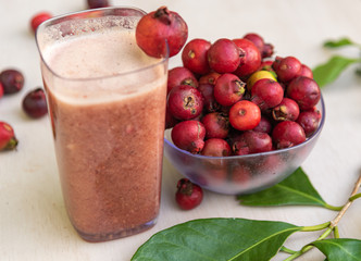 Glass of juice and fruits of red aracá (Psidium cattleyanum Sabine) in natura