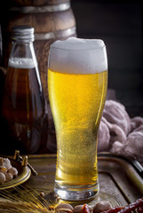 Light frothing beer in a glass, on an old background.