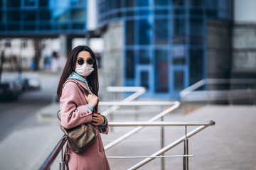 Female in medical protective mask outdoors in the empty city. Health protection and prevention of...