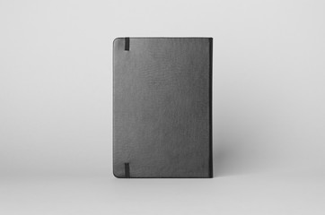 Black notebook mockup on a grey background. Backside.