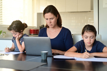 Single mother and daughters at home as the pandemic coronavirus (COVID-19) forces many employees...