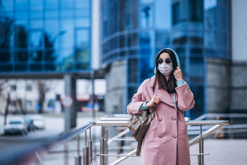Obraz premium Female in medical protective mask outdoors in the empty city. Health protection and prevention of virus outbreak, coronavirus, COVID-19, epidemic and pandemic, quarantine concept