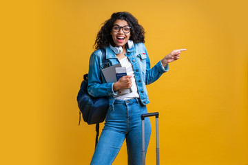 Beautiful dark skinned female tourist isolated on bright colored background