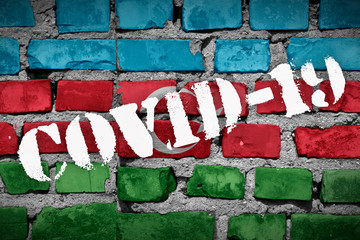Flag of Azerbaijan on the brick wall with sprayed stencil COVID-19 on it. 2019 - 2020 Novel...