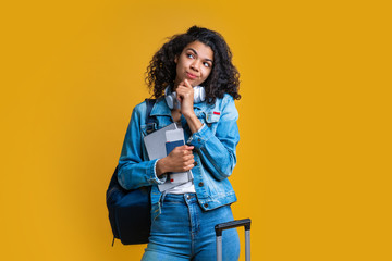 Beautiful dark skinned female tourist isolated on bright colored background
