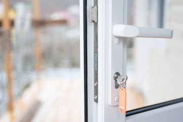 Street plastic glazed door with a key in the keyhole.