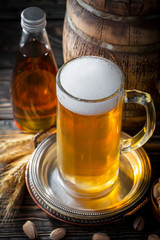 Light frothing beer in a glass, on an old background.